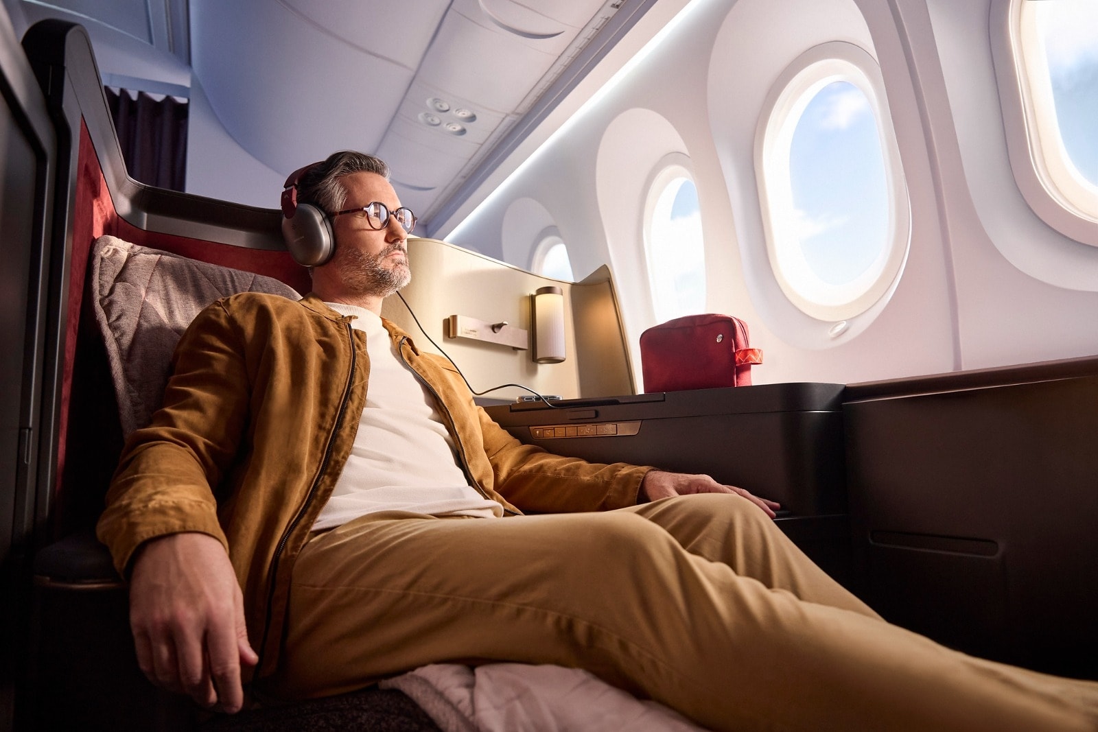Man relaxing in Avianca first class seat watching in-flight entertainment