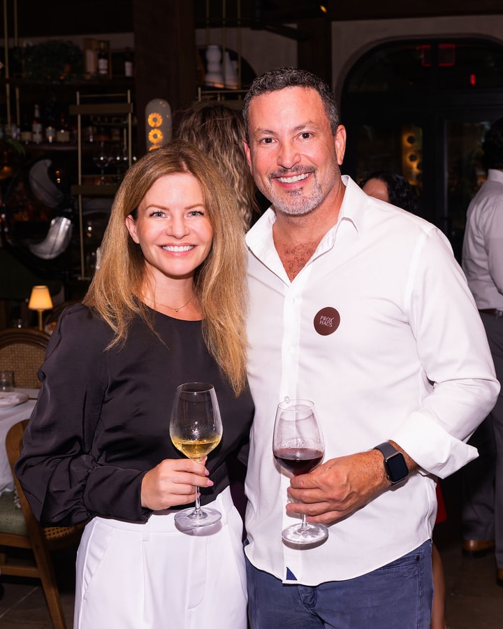 Two attendees with wine glasses at the PROXHAUS Miami kickoff at Claudie in Brickell