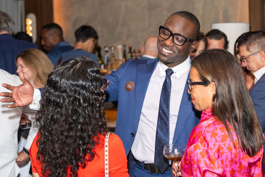 Man in blue suit with PROXHAUS badge networking at the Claudie launch event
