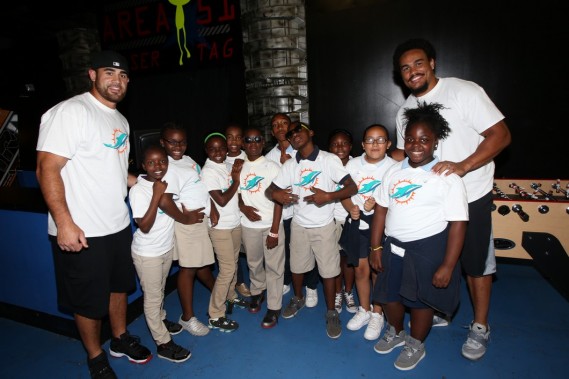 LB Koa Misi (left) and TE Dustin Keller (right) with students from Benjamin Franklin K-8 Center at Action Town in Hialeah