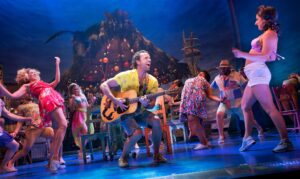 Paul Alexander Nolan, center, and the Broadway cast of Escape to Margaritaville. Sara Krulwich/The New York Times