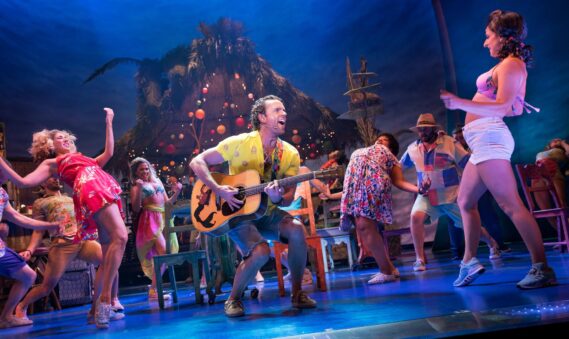 Paul Alexander Nolan, center, and the Broadway cast of Escape to Margaritaville. Sara Krulwich/The New York Times