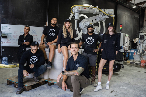 Founder and CEO, Anya Freeman, with robot and team at Kind Designs' warehouse in Miami, FL