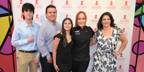 Chef Adrianne Calvo and St. Jude patient Crista and her family walk the red carpet at the St. Jude Thanks and Giving Holiday Event at Britto Palace.
