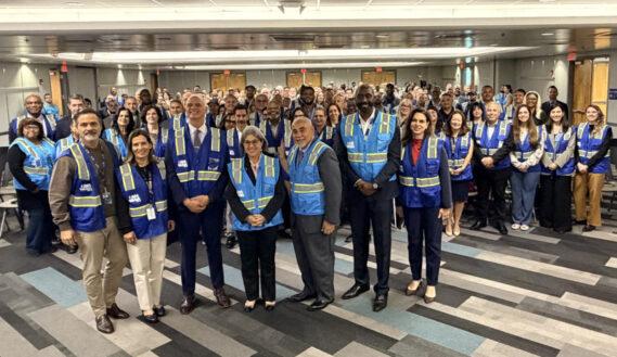 From left: American Airlines Miami Hub Vice President J.C. Liscano, MIA Acting Deputy Director of Operations Ana Finol, Miami-Dade County Mayor Levine Cava, Miami-Dade County Chief Operating Officer Jimmy Morales, MIA Deputy Director of Business Development Basil Binns, and MIA Chief of Staff Andria Muniz-Amador with frontline employees in I AM MIA Lightning Crew vests at MIA’s 2026 kickoff staff meeting.