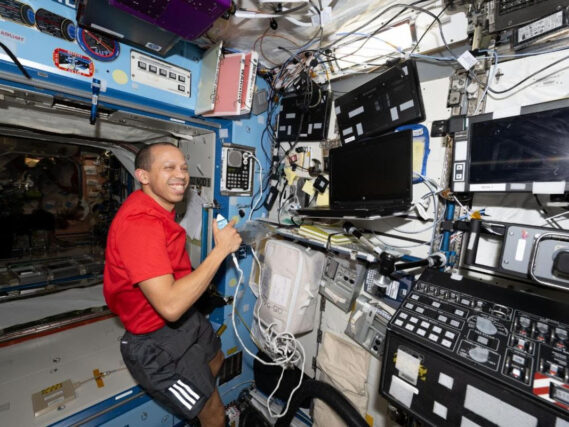 NASA astronaut Chris Williams calls mission controllers during Crew Medical Officer training while inside the International Space Station’s Destiny laboratory module. Credit: NASA/Jessica Meir
