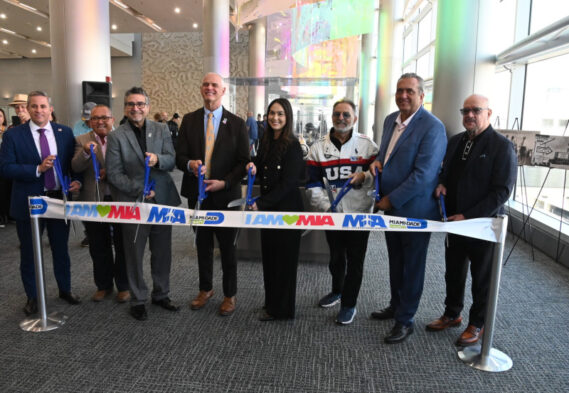 Cutting the ribbon at MIA on March 25 at the opening of Master of the Air, Builder of Dreams: Glenn Curtiss in South Florida were, from left: Miami-Dade County Tax Collector Dariel Fernandez, City of Opa-locka Commissioner Luis Santiago, City of Miami Springs Mayor Walter Fajet, MIA Director and CEO Ralph Cutié, Miami-Dade County Commissioner Natalie Milian Orbis, Miami Springs Councilman Jorge Santin, and GMCVB President and CEO David Whitaker.